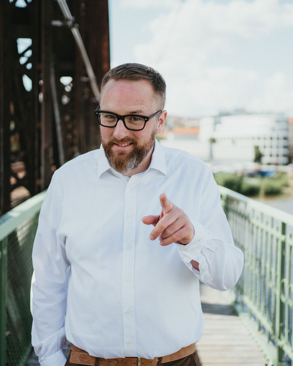 Ondřej Nečas v bílé košili ukazuje prstem do objektivu