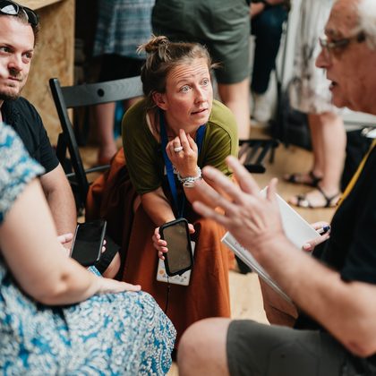 Malá skupina lidí v soustředěném rozhovoru na workshopu