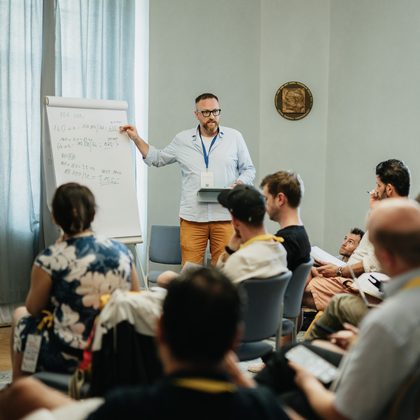 Ondřej Nečas vysvětluje u flipchartu skupině účastníků workshopu